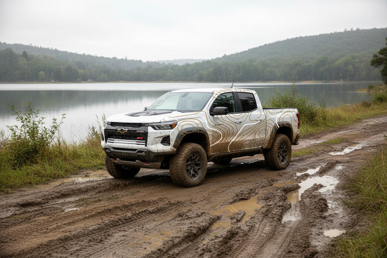Truck with topographic vinyl decals parked in the lake, overland style